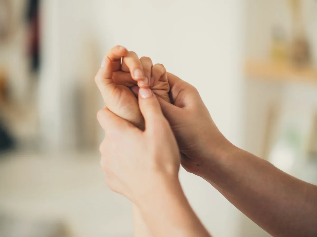 A physiotherapist mobilising a patient's finger joints.