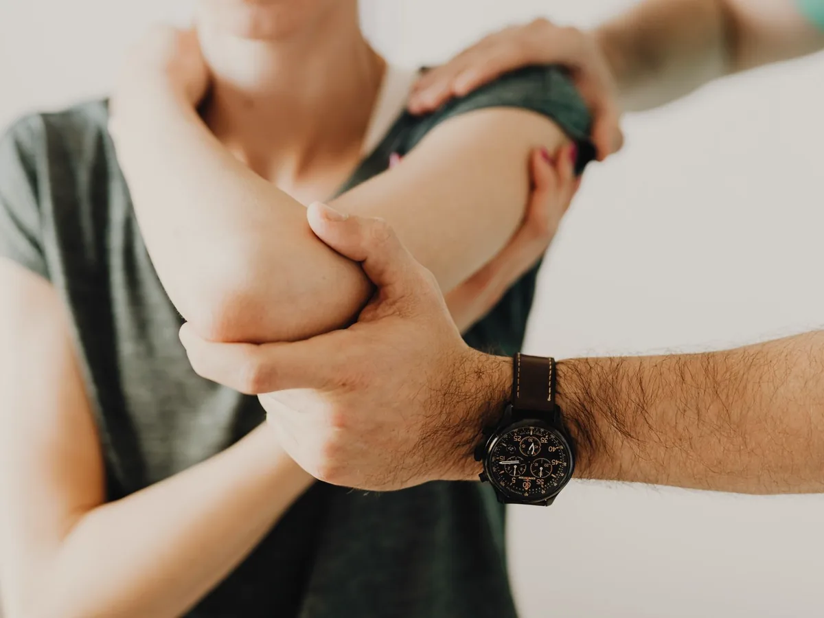 A physiotherapist assessing a patient's elbow.