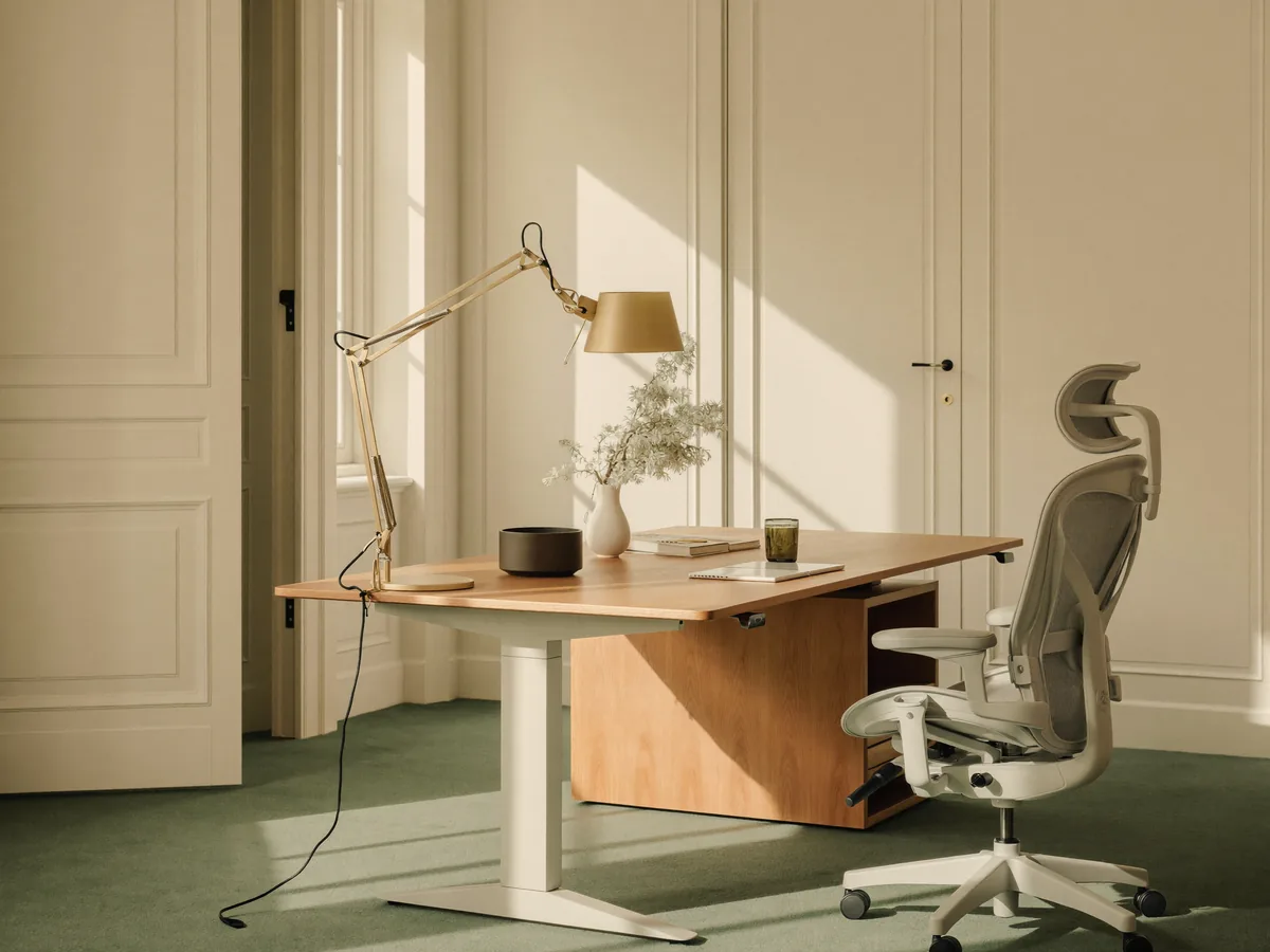 A refined, light-filled workspace with a height-adjustable desk and ergonomic chair.